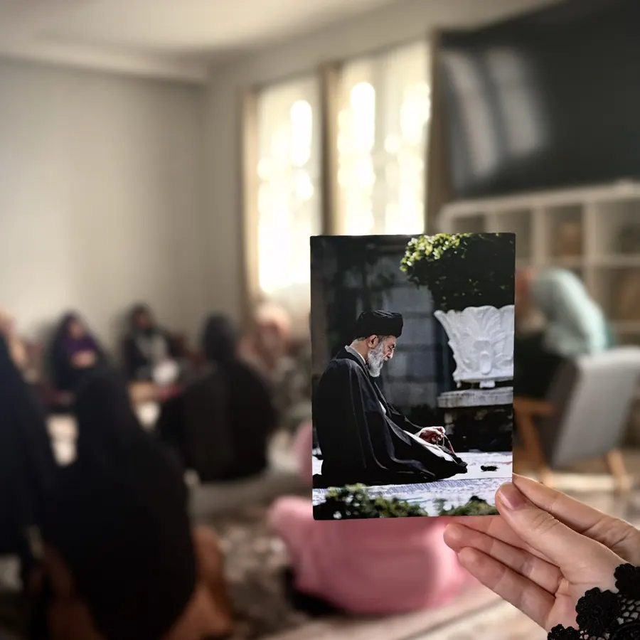 A sister holding a photograph during a gathering